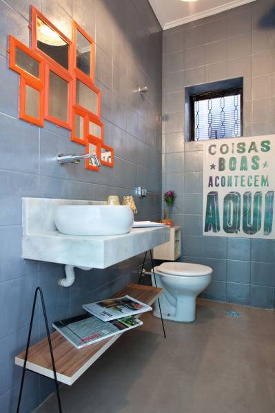 O cinza da parede deste lavabo vem do revestimento escolhido pelo escrit&oacute;rio Martinh&atilde;o Neves Arquitetos. Repare que o espelho &eacute; como um mosaico de pe&ccedil;as simples e pequenas.