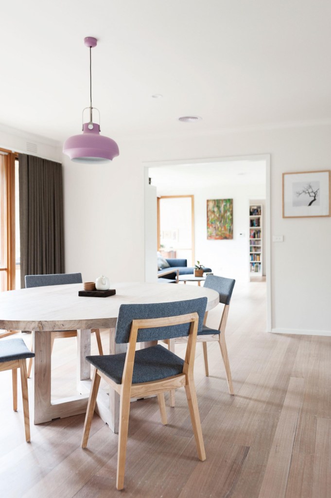 Sala de jantar; piso laminado; luminária rosa; mesa de pedra; mesa redonda; estilo escandinavo