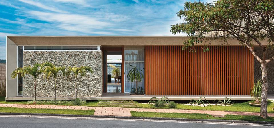 Uma casa sem muro, mas com brises e parede de mosaico