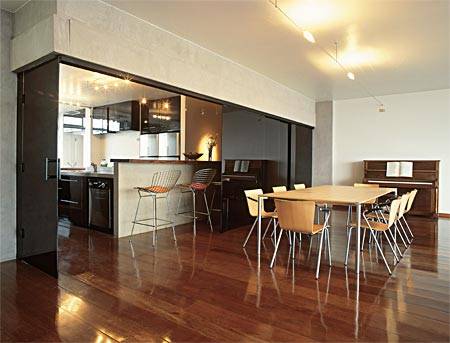 22 m&sup2;: Cinco folhas corredi&ccedil;as de vidro serigrafado preto oferecem flexibilidade a esta cozinha: quando fechadas, a deixam totalmente isolada. A continuidade entre os ambientes &eacute; reafirmada pelo piso de ip&ecirc;, tratado com seladora e cera para poder cobrir tamb&eacute;m a &aacute;rea junto &agrave; pia e ao fog&atilde;o, sujeita a respingos de &aacute;gua e gordura. Com arm&aacute;rios de laminado negro brilhante, o espa&ccedil;o, ponto alto de conviv&ecirc;ncia, &eacute; separado da sala de jantar por um balc&atilde;o de concreto, elemento tamb&eacute;m das vigas aparentes. Os materiais s&oacute;brios conferem ao apartamento a eleg&acirc;ncia desejada pela fam&iacute;lia, diz a arquiteta Adriana Levisky, de S&atilde;o Paulo.