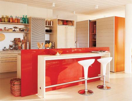 12 m&sup2;: O loft ocupado pelos pais &eacute; separado do espa&ccedil;o dos filhos nesta moradia. E, para que n&atilde;o falte nada ao casal, a estrutura conta inclusive com uma cozinha, ligada ao quarto. A localiza&ccedil;&atilde;o pediu cuidados extras, como o aconchego dado pela madeira. Que a limpeza fosse simples, era outro requisito  por&eacute;m, sem descuidar da beleza. O piso de laminado pl&aacute;stico se mostra excelente para ambos os objetivos, afirma Eduardo Passarelli, que assina o projeto em parceria com Marco Passarelli, ambos de S&atilde;o Paulo. A ilha central re&uacute;ne as fun&ccedil;&otilde;es de balc&atilde;o de refei&ccedil;&otilde;es e bancada de servi&ccedil;o, esta oculta por uma chapa vertical vermelha cheia de estilo, feita de p&oacute; de quartzo e granito processado.
