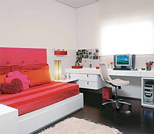 Para a irm&atilde; mais nova, de 7 anos, o arquiteto Toninho Noronha seguiu os mesmos moldes do quarto anterior: cama com bicama, bancada de estudo, paredes revestidas a meia altura de madeira laqueada e m&oacute;dulos para guardar roupas e brinquedos. "Mudei apenas as cores: rosa e laranja, conforme o pedido da ca&ccedil;ula", lembra. Na cabeceira, de 75 cm de altura, um toque inusitado: a lycra forra o painel de madeira e espuma.