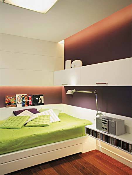 A jovem estudante de comunica&ccedil;&atilde;o queria conforto, descontra&ccedil;&atilde;o e cores especiais em seu quarto de 16 m&sup2;. "Utilizamos um futon como cama e local para ela se esparramar a qualquer hora, com f&aacute;cil acesso a computador, livros, som e TV", contam os arquitetos Paula Neder e Alexandre Monteiro. Pain&eacute;is de madeira pintados e v&atilde;os entre os planos deixam vazar a luz, criando uma ilumina&ccedil;&atilde;o agrad&aacute;vel. Uma estrutura de gesso junto ao teto acolhe ilumina&ccedil;&atilde;o embutida, destacando a parede colorida. A combina&ccedil;&atilde;o de roxo-fechado e verde-pistache propicia um contraste interessante.