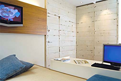 Natural, moderno e com solu&ccedil;&otilde;es pr&aacute;ticas. Era assim que a jovem de 18 anos desejava seu quarto de quase 17 m&sup2;. "Revestimos todo o ambiente com cores suaves, do piso ao teto, e encomendamos uma pintura especial na parede junto &agrave; cama, que &eacute; protegida por uma estrutura de madeira em toda a sua extens&atilde;o", diz a decoradora Paula Gambier. A cabeceira serve de fundo para a bancada de estudos. Ao lado, como se fosse um minicloset, a profissional bolou um canto repleto de prateleiras, reservado para guardar bolsas e sapatos. O lustre com pingentes completa a decora&ccedil;&atilde;o.