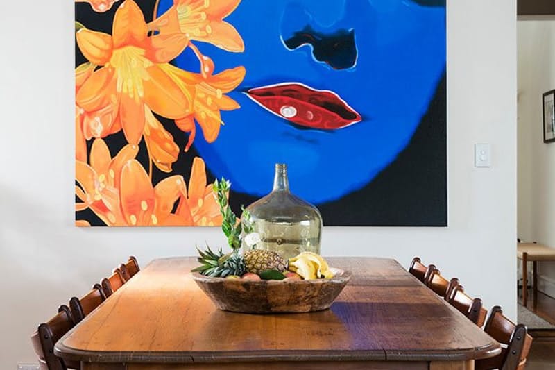 sala-de-jantar-com-mesa-baixa-de-madeira-e-quadro-impactante