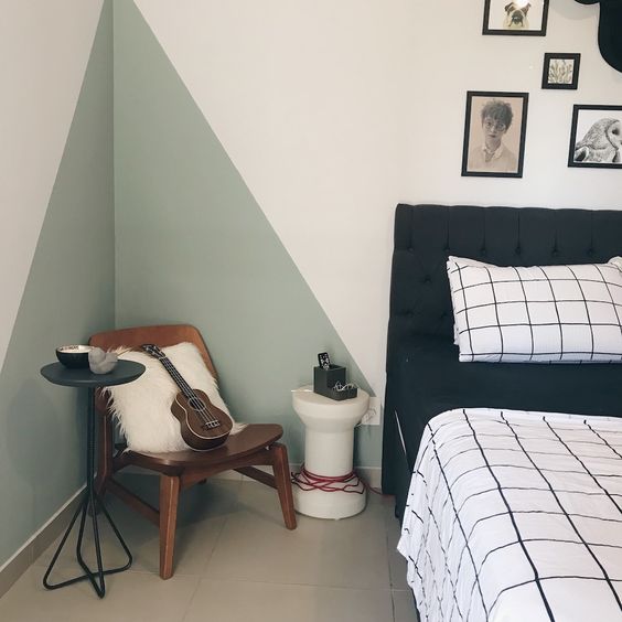 cama com conjunto quadriculado branco e preto e parede rosa claro com formas triangulares verde