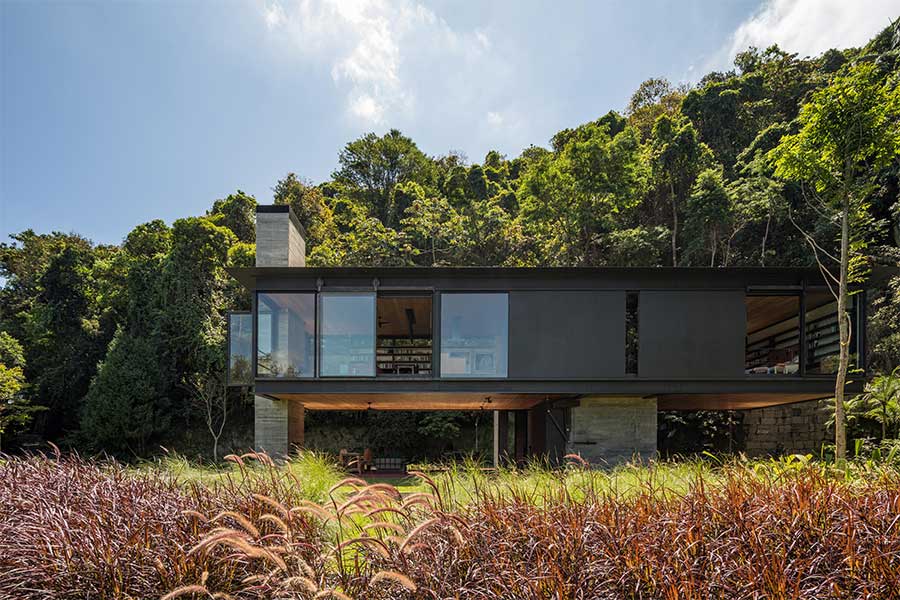 Casa de concreto e aço aberta para a natureza