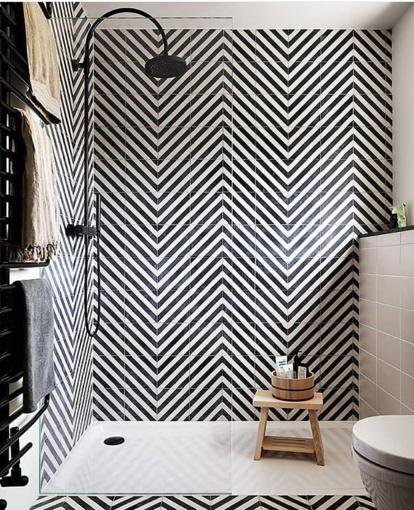 banheiro com revestimento em preto e branco
