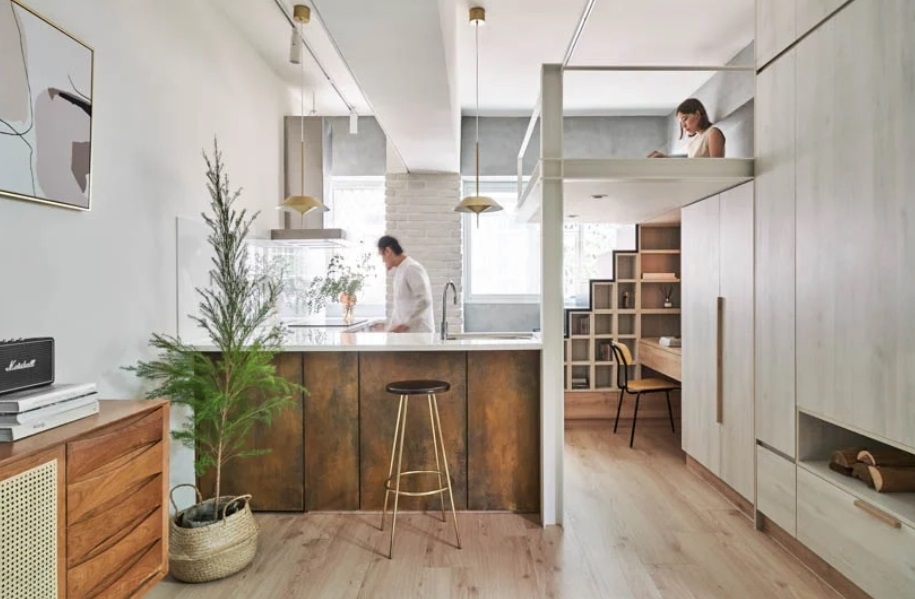 apartamento com piso em madeira, cozinha com bancada e um móvel em madeira com escada que leva a uma cama suspensa 