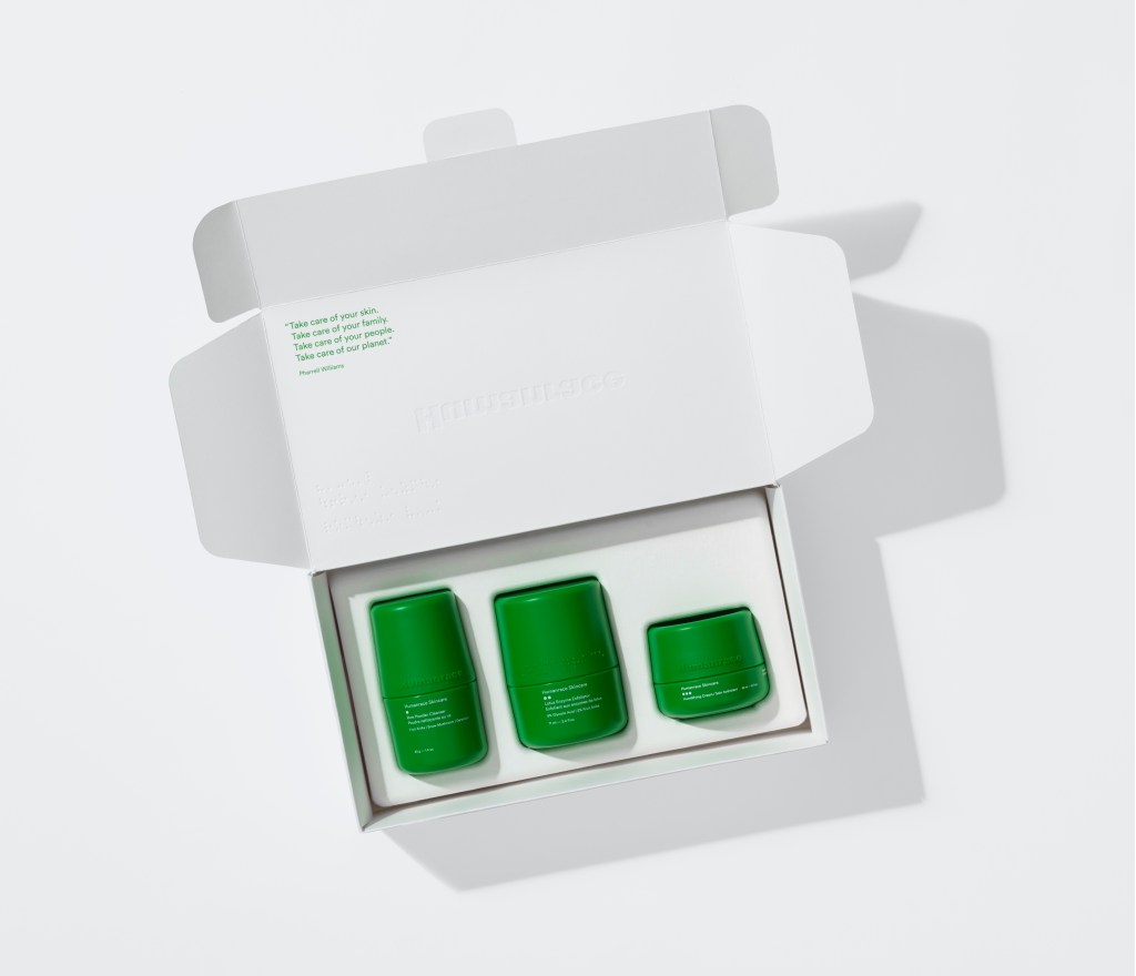 Caixa branco aberta com os três produtos de cuidado facial, de embalagens verdes.