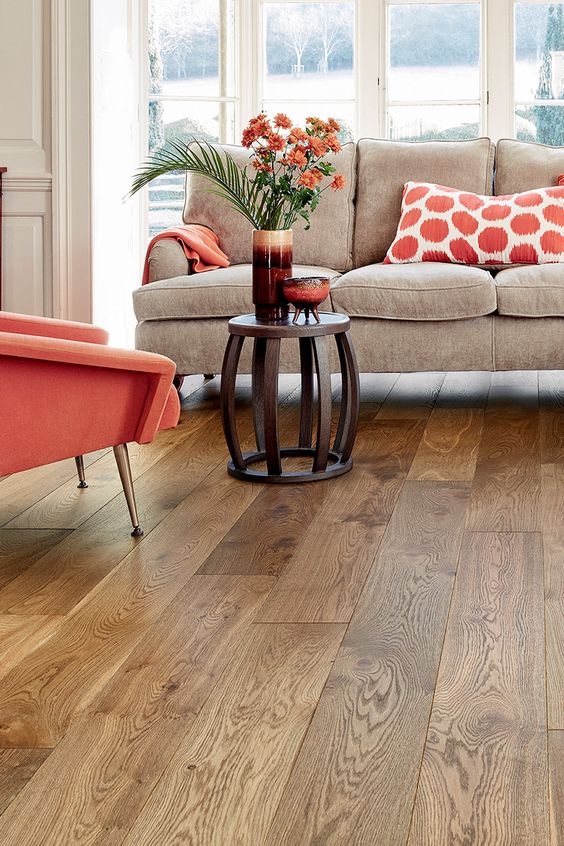 piso-vinilico-ou-laminado-casa.com-6 Sala de estar com sofá, decoração com detalhes em laranja e piso laminado.