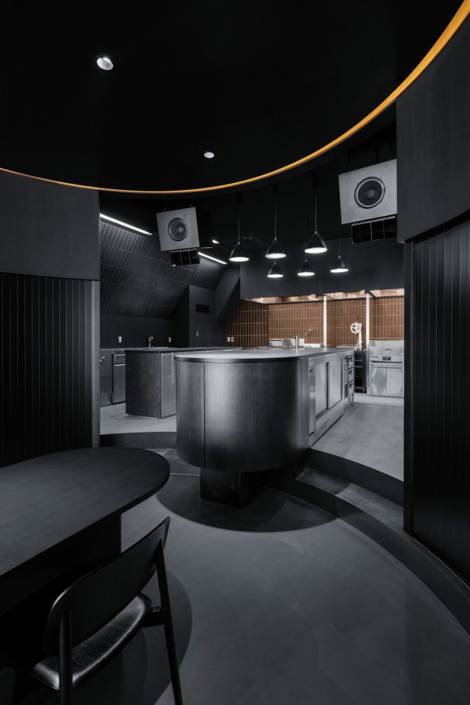 Ambiente monocromático: restaurante foca no preto e em cozinha em formato de palco Ambiente monocromático: restaurante foca no preto e em cozinha em formato de palco