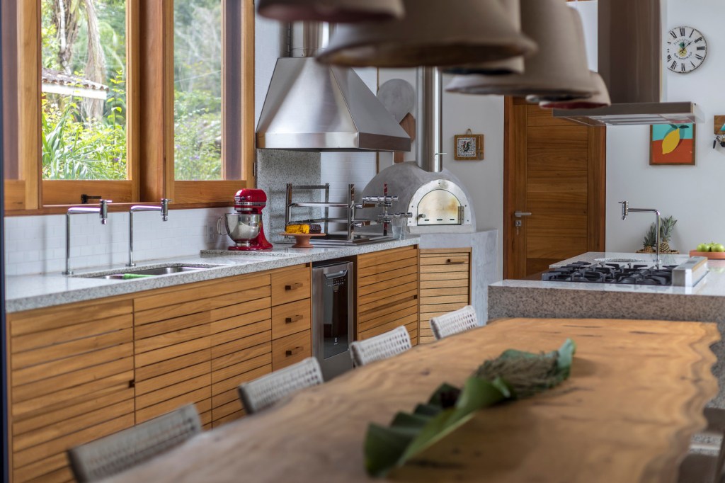 17-casa-de-236-m-2-integra-ambientes-e-traz-a-natureza-para-interior Cozinha e sala de jantar com presença de muita madeira de casa