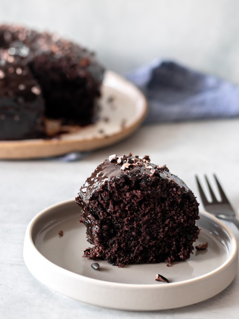 Pedaço de bolo de chocolate vegano, com cobertura de chocolate e granulado