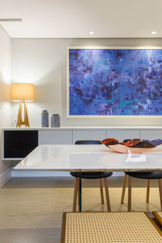 Sala de jantar com abajur sobre buffet ao fundo