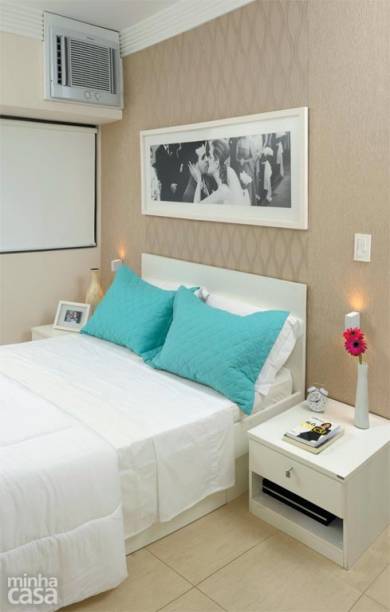 O quarto da designer de interiores Gabriela Alencar tem apenas o essencial: um par de criados-mudos e a cama com gavet&otilde;es para len&ccedil;&oacute;is, mantas e toalhas. A parede da cabeceira foi revestida de papel de parede em dois padr&otilde;es com texturas beges.