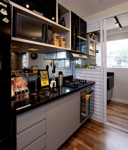 <span>Presença forte, o preto aparece nos móveis, na geladeira e até mesmo na iluminação, e é suavizado pelo uso da madeira. O porcelanato que imita o material natural (Grápia Rústico,da Itagres, Leroy Merlin) cobre o piso de todo apê (exceto o do banheiro). Projeto da arquiteta Carolina Ouro.</span> <span>Presença forte, o preto aparece nos móveis, na geladeira e até mesmo na iluminação, e é suavizado pelo uso da madeira. O porcelanato que imita o material natural (Grápia Rústico,da Itagres, Leroy Merlin) cobre o piso de todo apê (exceto o do banheiro). Projeto da arquiteta Carolina Ouro.</span>