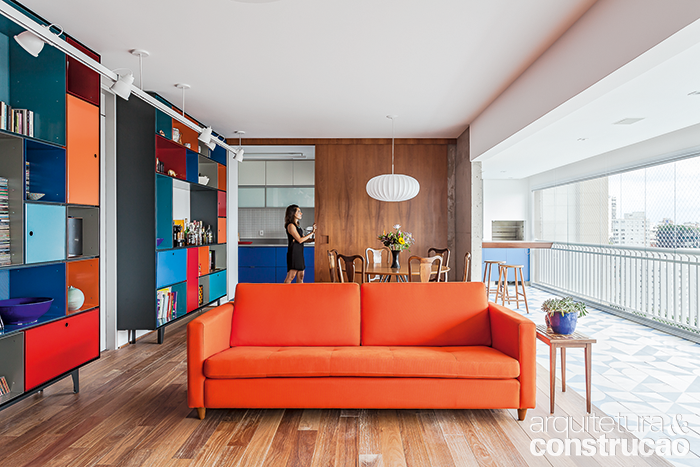 A pedido dos propriet&aacute;rios, que queriam um ambiente marcante e j&aacute; tinham o sof&aacute;, o projeto investiu na combina&ccedil;&atilde;o de nuances vivas, sobretudo na estante modular (Brasiliana, da Securit). O piso do estar &eacute; de cumaru (Projeto Madeiras).