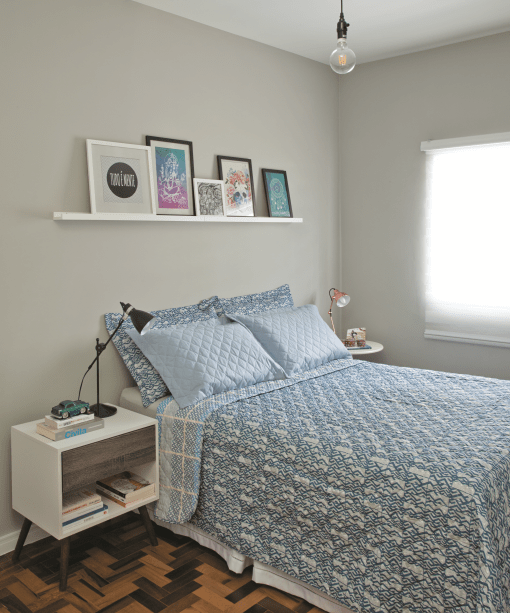 <span>Um tom neutro de prata nas paredes destaca os quadros coloridos apoiados na prateleira.&nbsp;</span><span>Nas laterais da cama, ela seguiu a tend&ecirc;ncia de criados-mudos descombinados, com lumin&aacute;rias tamb&eacute;m diferentes.&nbsp;Acr&iacute;lica, na cor Prata, ref. C161, da Suvinil.</span>