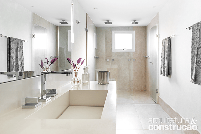 Os dois banheiros originais viraram um s&oacute;, com paredes revestidas de textura efeito limestone&nbsp;(Terracor, ref. tom 21). No piso, porcelanato de 0,60 x 1,20 m (padr&atilde;o Concret&iacute;ssyma Nude, da Portobello). Bancada de Silestone branco.