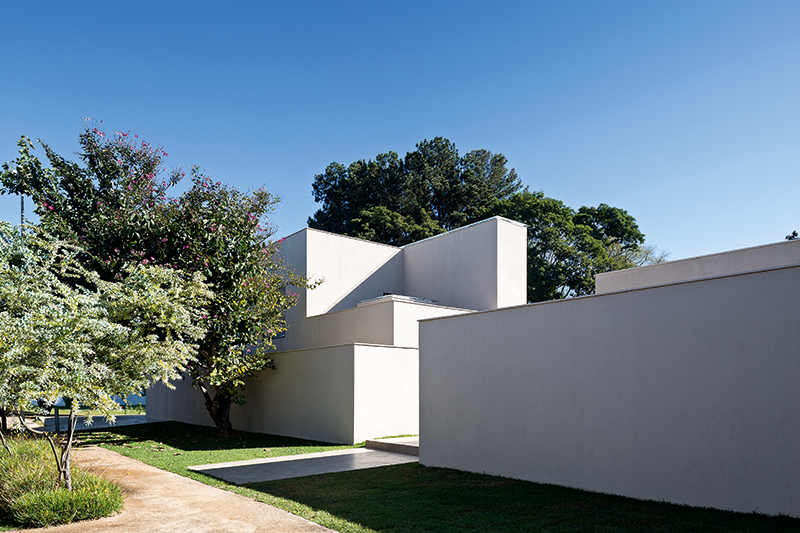 Casa Paineira, Bras&iacute;lia, 2014: reunidos os volumes mais altos no centro da constru&ccedil;&atilde;o, restaram&nbsp;afastadas paredes de 2,20 m de altura. Mais do que&nbsp;muros, elas delimitam amplos jardins internos e servem &agrave; proje&ccedil;&atilde;o&nbsp;das sombras da grande paineira existente no terreno.
