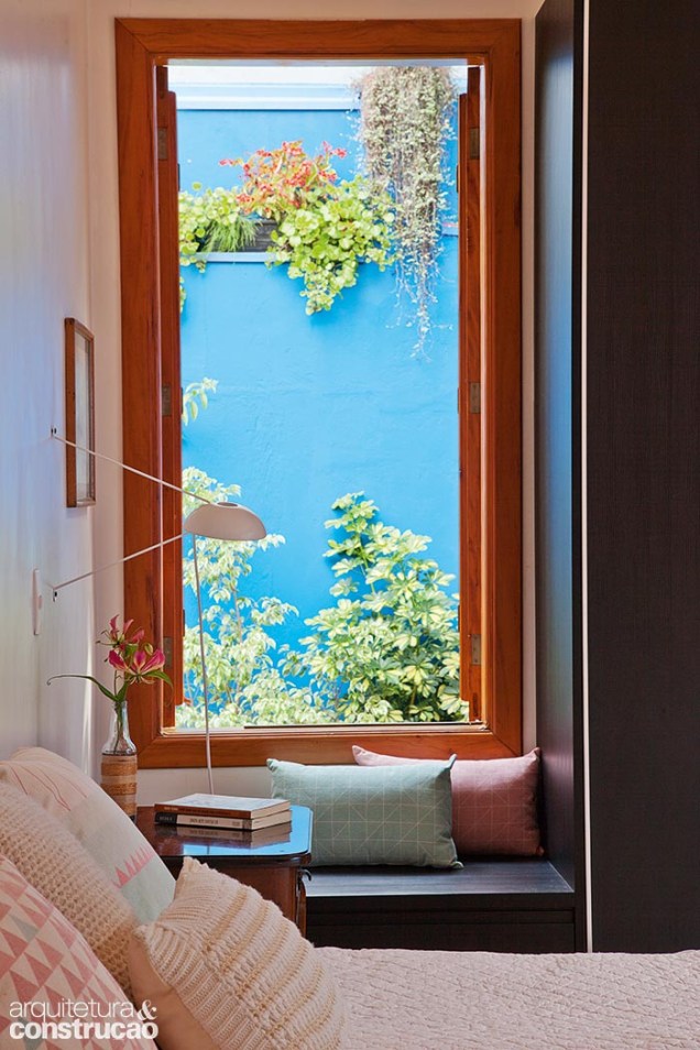 Ao lado da cama, a janela com banco de madeira (Luciano Santos) completa a vista para o verde e azul do jardim. Ao lado da cama, a janela com banco de madeira (Luciano Santos) completa a vista para o verde e azul do jardim.