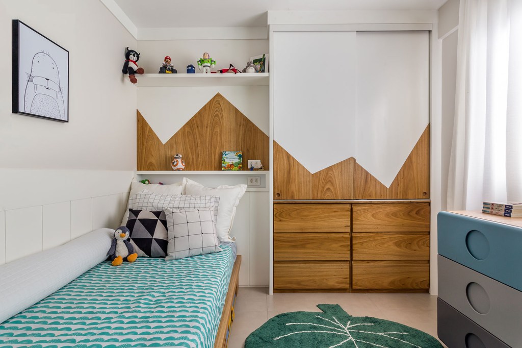 Quarto infantil, com roupa de cama verde, tapete em fomarto de planta, guarda roupa com desenho de montanha