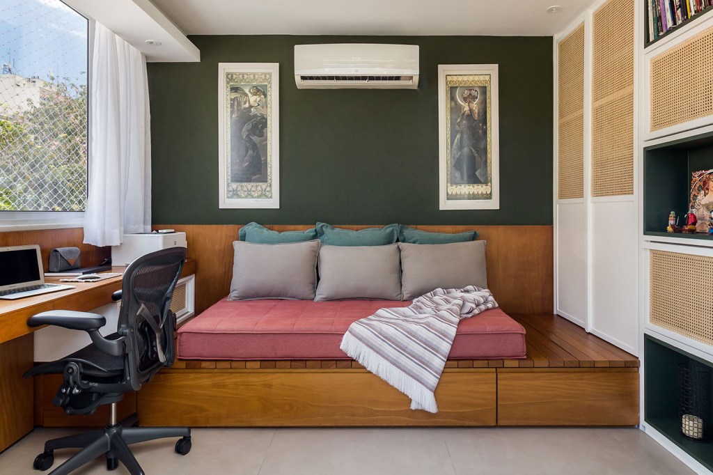 no-rio-cobertura-duplex-de-130-m²-ganha-projeto-de-decoracao-e-marcenaria-casa.com-co+lab-arq-e-int-luiza-schreier-5 Sofá cama com colchão rosa, e almofadas verde e conza. Parede verde com dois quadros