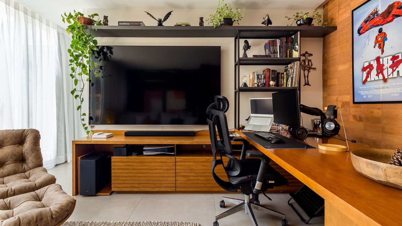 Tv grande, com rack de madeira e prateirla acima com plantas decroativas