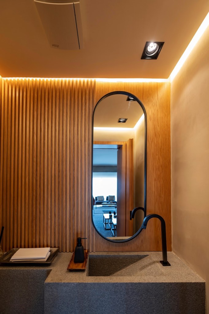 Hora-da-make-como-a-iluminação-ajuda-na-maquiagem-03 Muito charme neste lavabo com a presença de vários materiais como madeira e pedra. Na iluminação, plafons e fitas de led contribuem com a funcionalidade do espaço