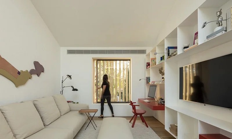 Nesse ambiente estreito, a estante emoldura a TV e acompanha toda a parede com funções diferenciadas, otimizando o espaço. Projeto de Amanda Castro e Giovana Giosa Nesse ambiente estreito, a estante emoldura a TV e acompanha toda a parede com funções diferenciadas, otimizando o espaço. Projeto de Amanda Castro e Giovana Giosa