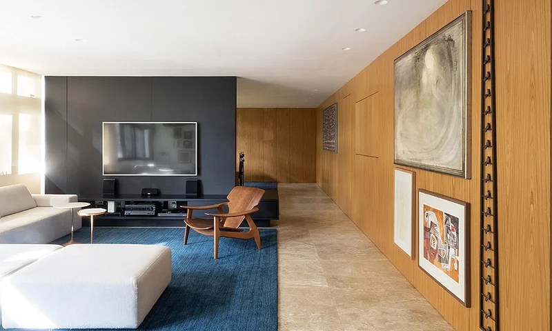 Aqui o rack e a parede cinza acompanham a TV mesclando-se ao ambiente. Projeto de Bloco Arquitetos Aqui o rack e a parede cinza acompanham a TV mesclando-se ao ambiente. Projeto de Bloco Arquitetos