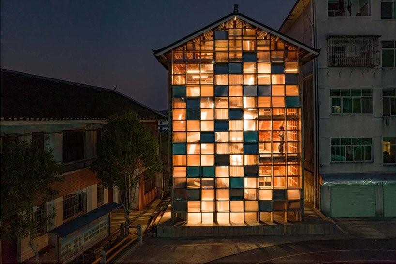 matriz-estantes-compoe-fachada-luminosa-china-sai-zhao-biblioteca-fachada-translucida-policarbonato Vista noturna da fachada de biblioteca com fachada luminosa formada por estantes de livros.
