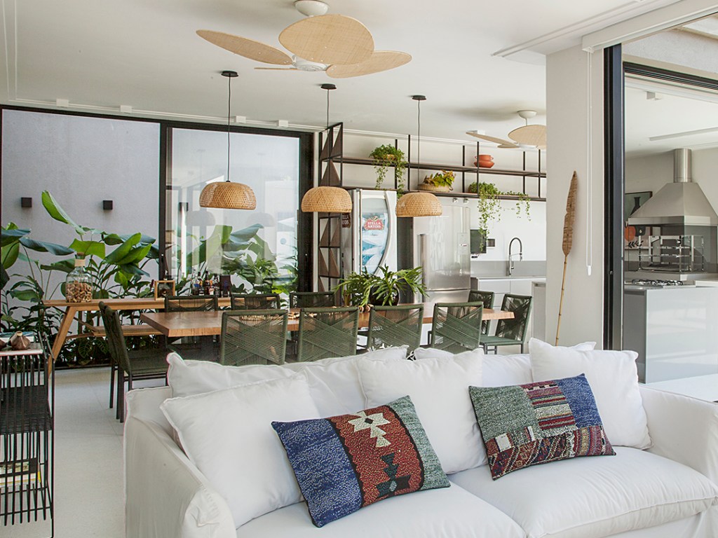 1-espaço-multifuncional-o-que-e-e-como-criar-o-seu Sala de estar integrada ao jantar com sofá branco, mesa de jantar e pendentes de iluminação
