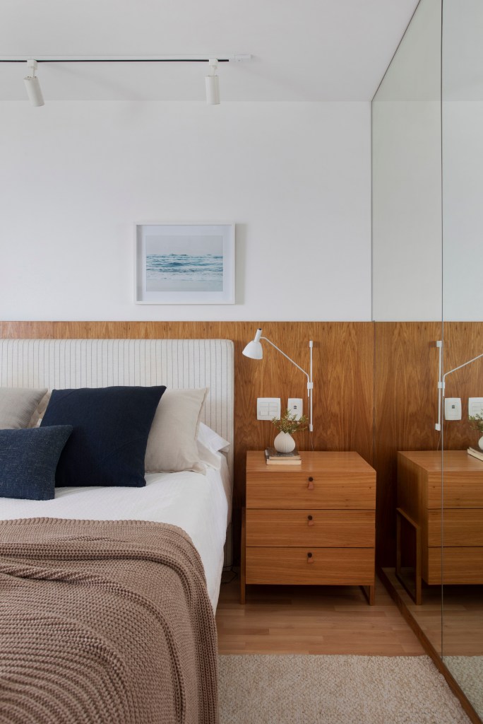 18-reforma-deixa-ape-de-150-m-2-mais-iluminado-e-com-ambientes-leves Quarto de casal com cabeceira de madeira e escrivaninha também de madeira