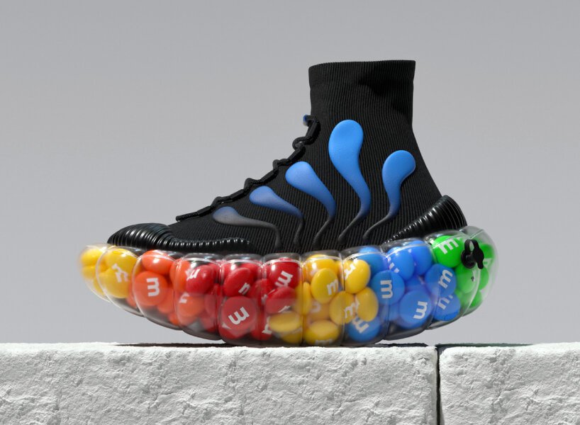 Sapatos inflaveis voce usaria-Designboom (11) Tênis preto com detalhes azuis cuja sola é inflada, lembrando uma boia de praia. A sola transparente deixa transparecer M&Ms.