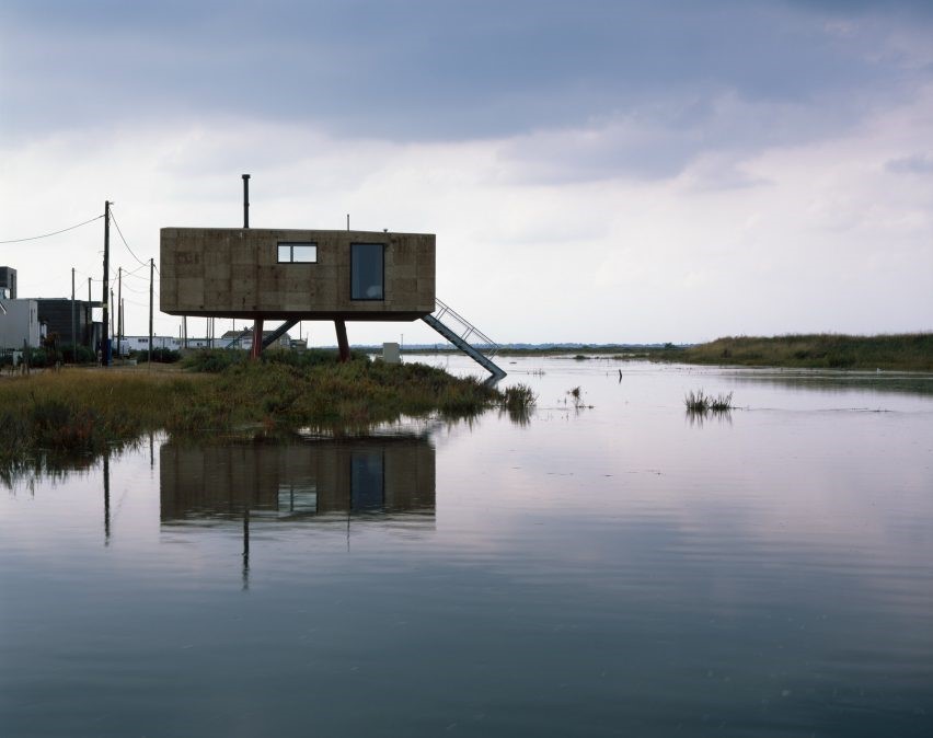 dez-casas-sobre-palafitas-hélène-binet-cortiça-madeira-clt-aço-galvanizado Foto mostra casa sobre palafitas à beira da água, que parece um lago.