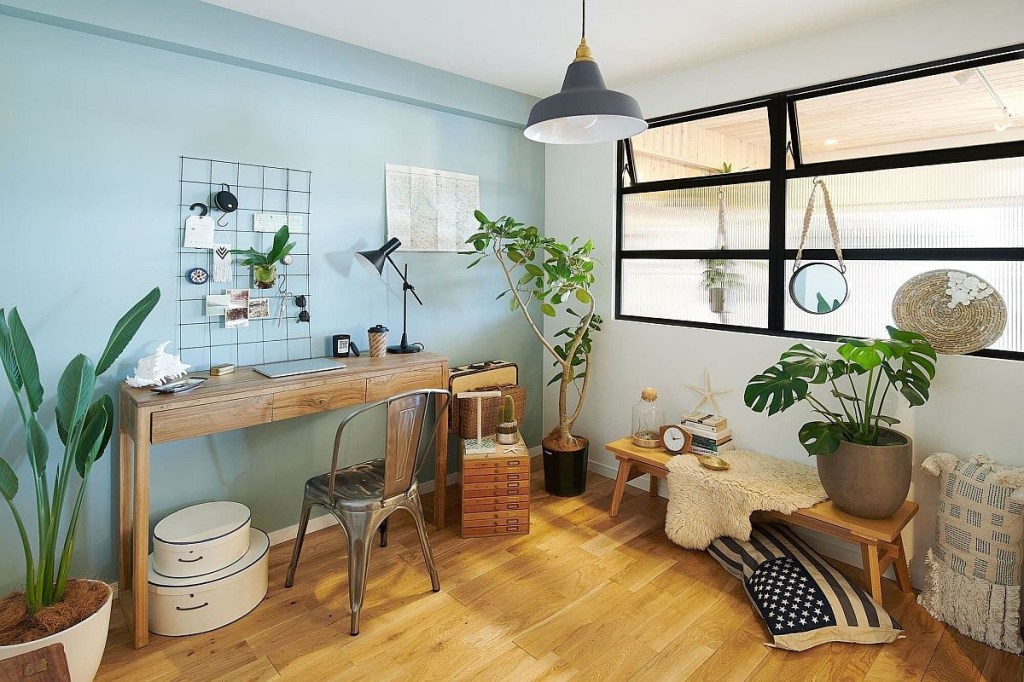 Home office de paredes verdes. Algumas plantas decoram o ambiente.