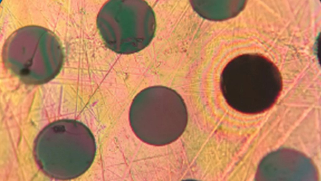 10-materiais-que-podem-mudar-a-construção-divulgação-dezeen-plastico-superforte Foto mostra detalhe de material de cor alaranjada com círculos pretos.