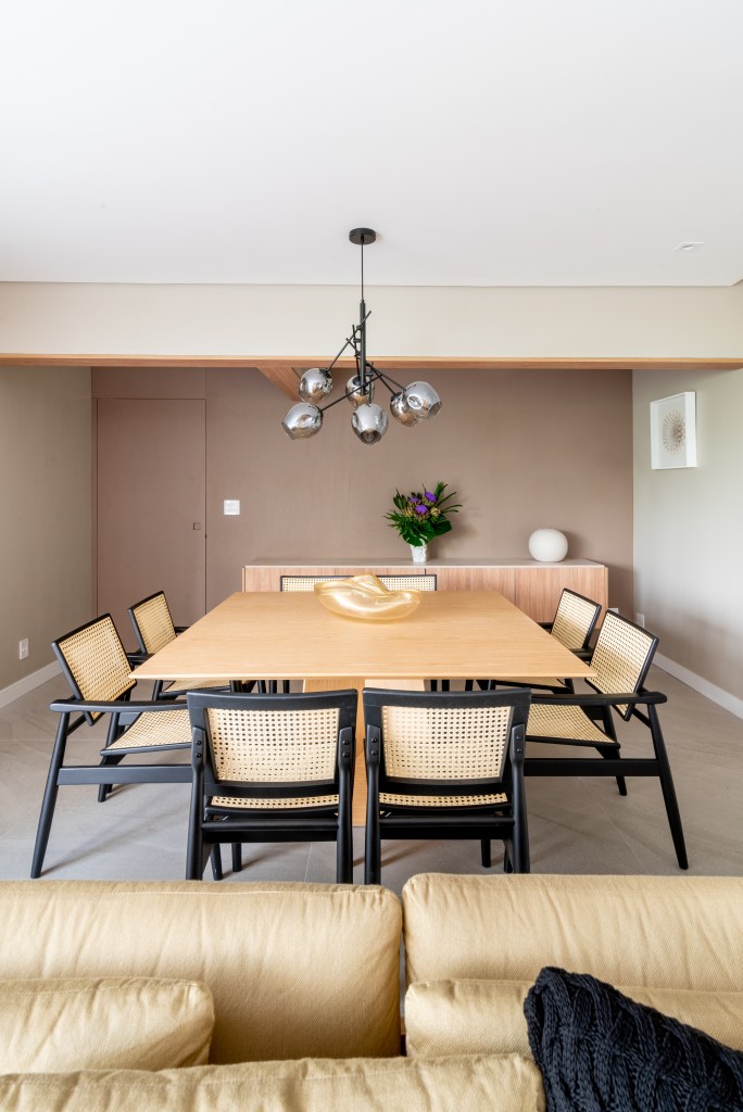 Sala de jantar com mesa em madeira e luminária pendente