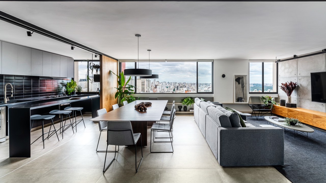 Sala de estar integrada com cozinha e jantar; grandes janelas ao fundo