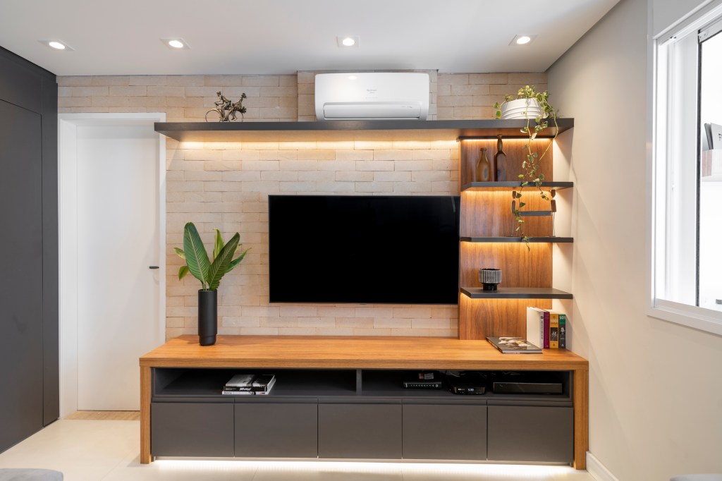 Reforma-em-ape-de-55-m2-oferece-area-social-mais-ampla-projeto-Base-Arquitetura-foto-Flavio-Estudio-360-tijolinhos-tv-led-movel Área de TV com tijolinhos e estantes com LED
