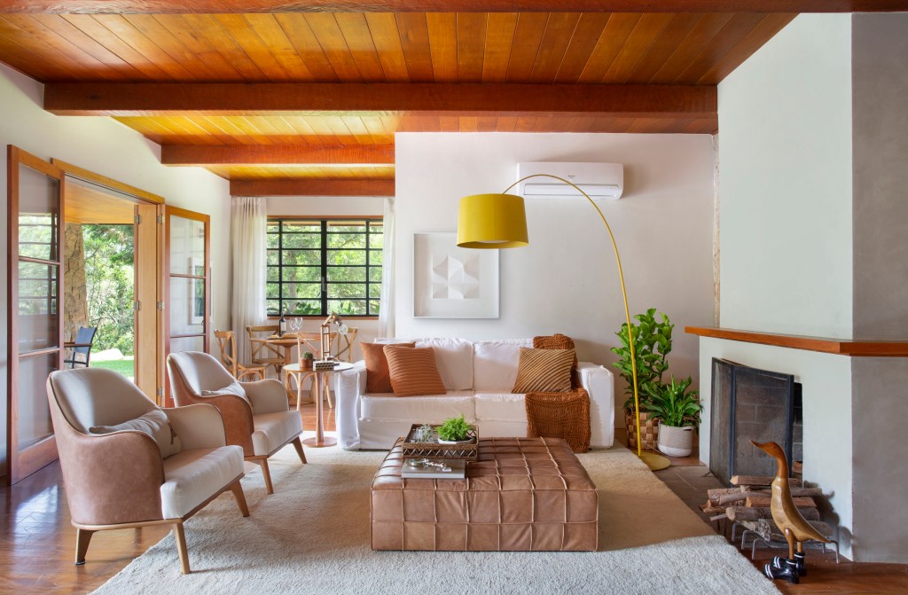 Casa-de-campo-de-250-m2-apresenta-decoracao-com-muita-madeira-projeto-Natalia-Lemos-Paula-Pupo-Juliano-Colodeti-sala-de-estar-luminaria-paleta Sala de estar com tons terrosos