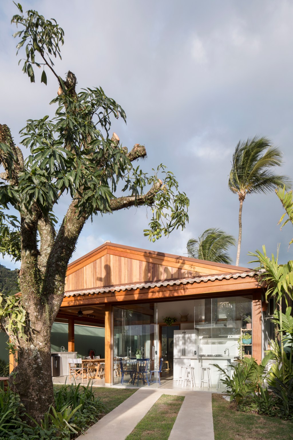 Casa na praia de 140 m² se torna mais ampla com paredes de vidro