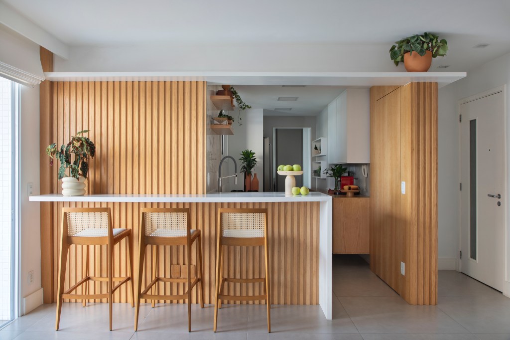 Cópia de Cobertura linear com 260m2 em Icaraí, bairro de Niterói no RJ, assinada pelo escritório IKEDA ARQUITETURA _ foto 5 Cozinha com bancada e revestimento em madeira ripada