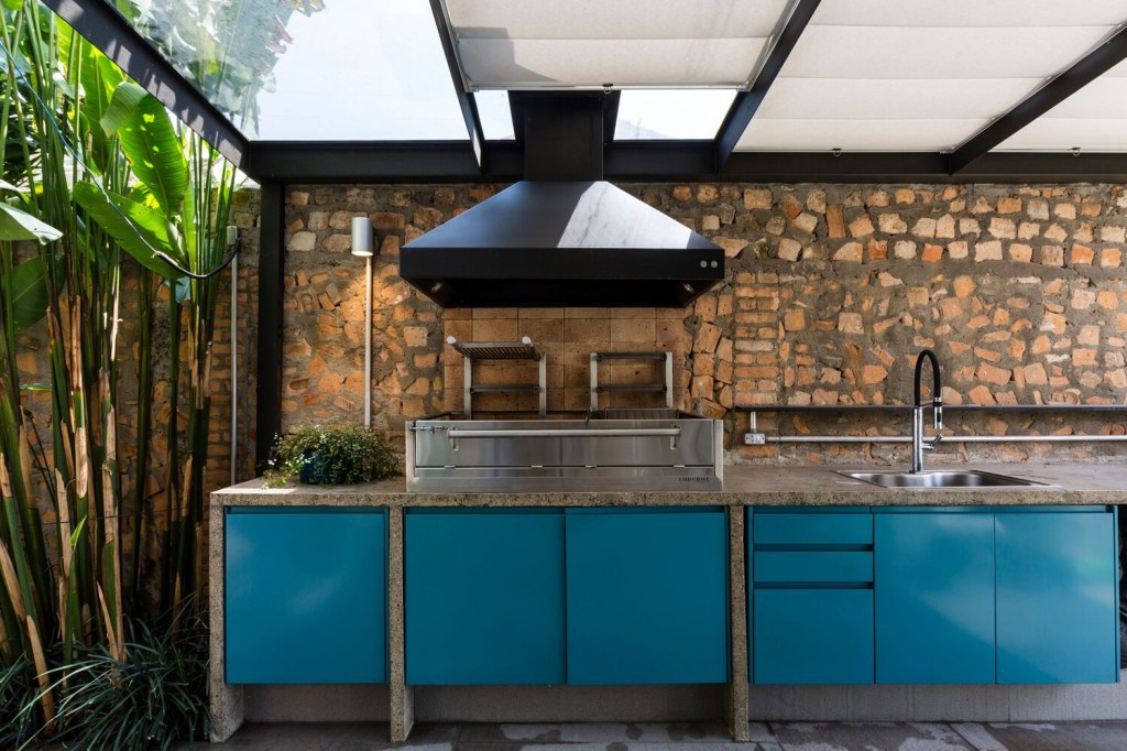 casa-paredes-de-entulho-massimo-failutti-area-gourmet-jardim-armario-azul Área gourmet tem parede de entulho na bancada de trabalho com armários pintados de azul e cobertura translúcida integrada ao jardim.
