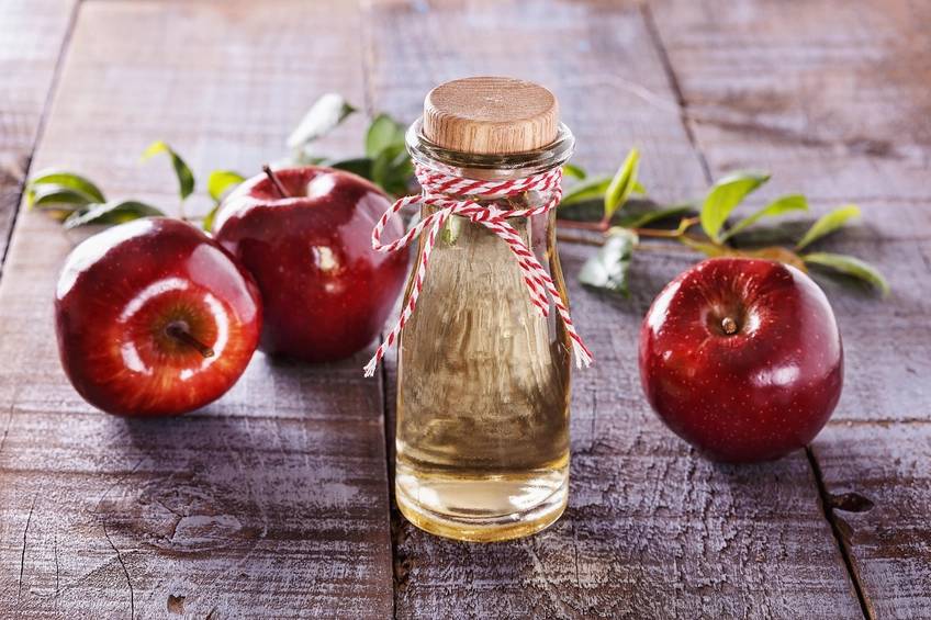 Frasco de vidro com vinagre e ma&ccedil;&atilde;s ao redor