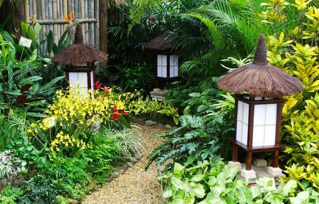 Jardim com caminho de pedras e luminárias estilo oriental