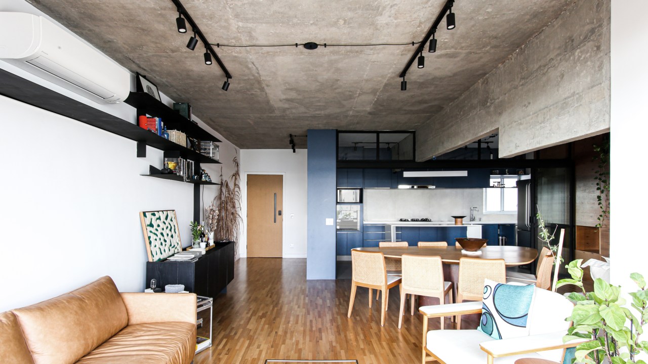 Sala de estar integrada com jantar e cozinha; laje em concreto