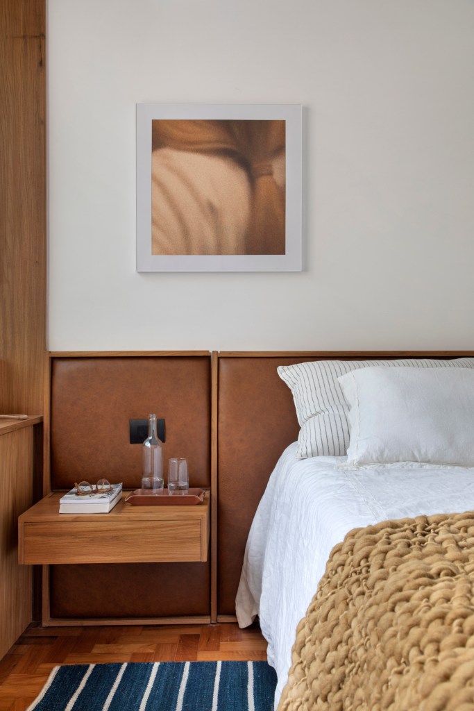 Quarto; cabeceira de couro; cama; mesa lateral